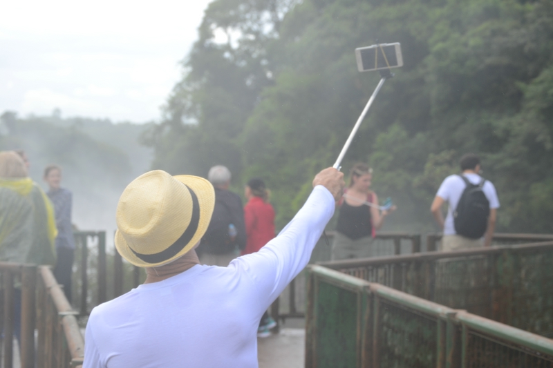 турист делает селфи с видом на водопады Iguasu